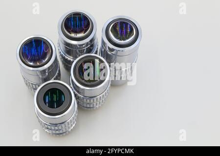 Beaucoup d'objectifs différents de l'agrandissement sur un fond blanc. Gros plan des objectifs du microscope. Banque D'Images