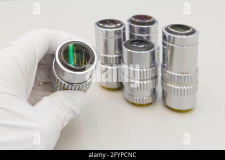 Beaucoup d'objectifs différents de l'agrandissement sur un fond blanc. Gros plan des objectifs du microscope. Banque D'Images