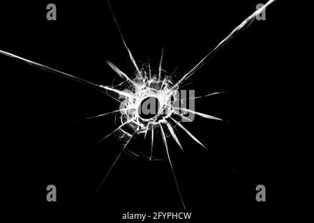 Illustration d'une texture de verre brisée avec un trou au centre isolé sur un fond noir. L'effet des fissures sur la vitre Banque D'Images