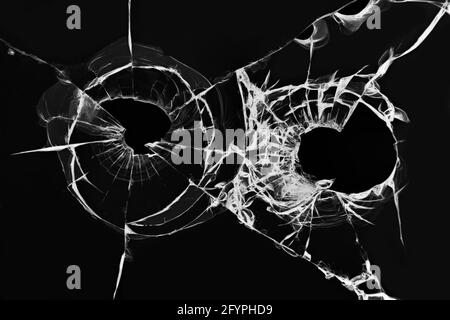 L'effet du verre brisé d'une prise de vue. Illustration de trous de balles de pistolet dans le pare-brise d'une voiture sur fond noir Banque D'Images