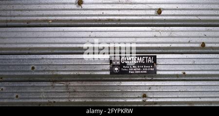 Détail d'une publicité guatémaltèque apposée sur un volet abstrait en métal rouillé Banque D'Images