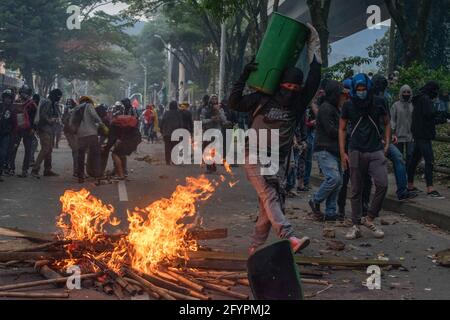 Les manifestants transportent des trashcans et des conteneurs pour atténuer les gaz lacrymogènes tandis que les manifestants protestent contre le président Ivan Duque et la brutalité policière après un mois de manifestations qui avaient fait au moins 45 morts dans des troubles et des cas d'abus de pouvoir de la police, à Medellin, Antioquia - Colombie le 28 mai 2021. Banque D'Images