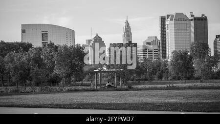 Couple à une date à Columbus Ohio dans un parc balançant en regardant le paysage de la ville noir et blanc Banque D'Images