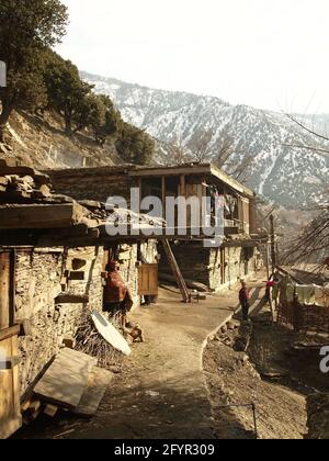 Kalash femme et garçon en robe traditionnelle. Village païen éloigné de Rumbur dans les vallées de Kalasha, Hindu Kush, nord du Pakistan, hiver 2013 Banque D'Images