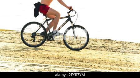 2019: le biker fait du vélo de montagne russe Stels-630 le long d'une plage de sable ensoleillé Banque D'Images