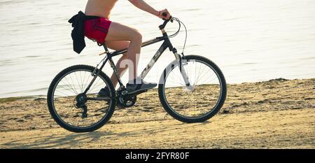 2019: le biker fait du vélo de montagne russe Stels-630 le long d'une plage de sable ensoleillé Banque D'Images