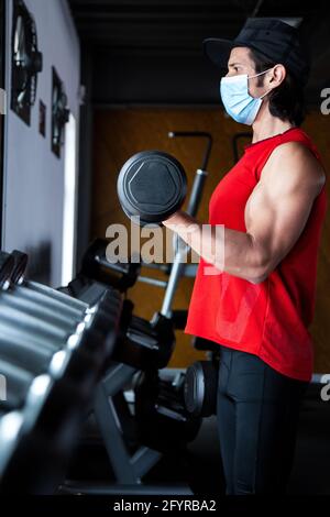 FIT mexicain gars entraînement curl biceps à la salle de gym pendant la pandémie de COVID Banque D'Images