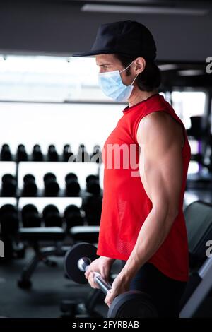 FIT mexicain gars entraînement curl biceps à la salle de gym pendant la pandémie de COVID Banque D'Images