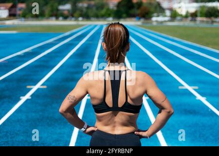 Dos d'une jeune athlète féminine debout sur un terrain d'athlétisme piste Banque D'Images