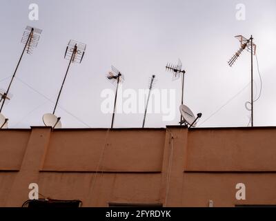 Photo à angle bas des antennes sur le toit d'une maison pendant la journée Banque D'Images