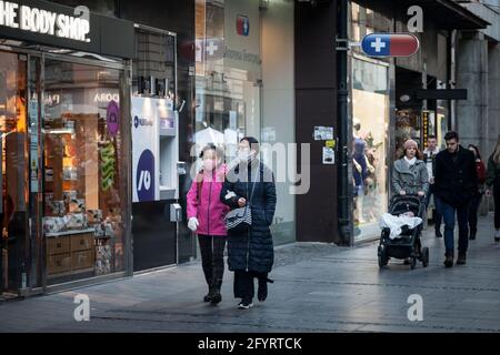 BELGRADE, SERBIE - 13 MARS 2021: Flou sélectif sur deux femmes, d'âge moyen, asiatiques, amis, marchant en hiver en portant un masque respiratoire dans le Banque D'Images