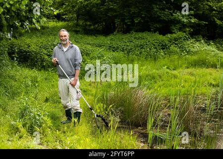 Offenburg, Allemagne. 27 mai 2021. Hubert Laufer, expert en amphibiens, se trouve à côté d'un étang. Selon les spécialistes de la conservation des espèces, la sécheresse de ces dernières années et l'empiètement des humains et de l'industrie sur le paysage menacent de plus en plus les grenouilles, les salamandres et les crapauds du Bade-Wurtemberg. (À dpa 'le nombre d'amphibiens dans la migration des crapauds continue de diminuer significativement') Credit: Philipp von Ditfurth/dpa/Alamy Live News Banque D'Images