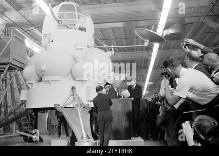 12 septembre 1962le président John F. Kennedy (au lectern) prononce un discours, à la suite d'une visite d'expositions d'engins spatiaux à l'intérieur d'un hangar au Rich Building of the Hided vaisseau spatial Center, Houston, Texas. Le président Kennedy détient un modèle à échelle du module de commande Apollo, qui lui a été présenté par le directeur du centre spatial habité, le Dr Robert Gilruth ; une maquette de l'omble lunaire (également connu sous le nom de « bogue ») est en arrière-plan. En arrière-plan : Administrateur de la National Aeronautics and Space Administration (NASA), Dr. James E. Webb; Gouverneur du Texas, Price Daniel; Banque D'Images