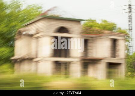 Image floue de mouvement d'un bâtiment de bord de route non fini et abandonné. Maison abandonnée dans le flou. Banque D'Images