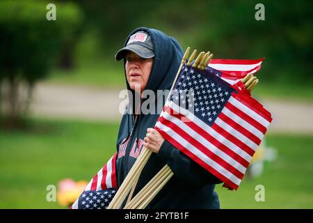 Bloomington, États-Unis. 29 mai 2021. Angie Bowman aide à placer des drapeaux américains dans les jardins Valhalla Memory Gardens pour le Memorial Day Samedi. Le Memorial Day, qui est le lundi 31 mai de cette année, est une fête fédérale pour honorer les membres des Forces armées des États-Unis qui sont morts dans l'exercice de leurs fonctions. Crédit : SOPA Images Limited/Alamy Live News Banque D'Images