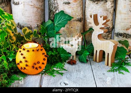 Deux ders en bois et une mandre orange décorée de trèfle. Décoration de table de Noël de style traditionnel. Banque D'Images