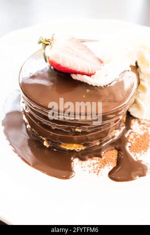 Crêpe au chocolat avec fraise sur une assiette blanche Banque D'Images