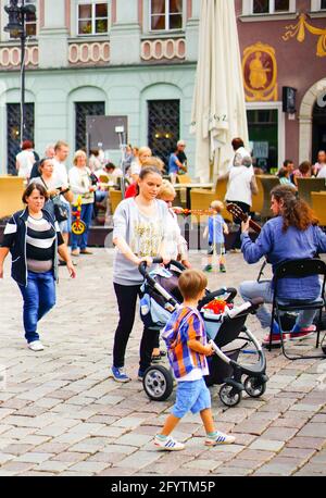 POZNAN, POLOGNE - 06 février 2016 : une femme non identifiée avec une poussette qui marche sur une place de la ville bondée Banque D'Images