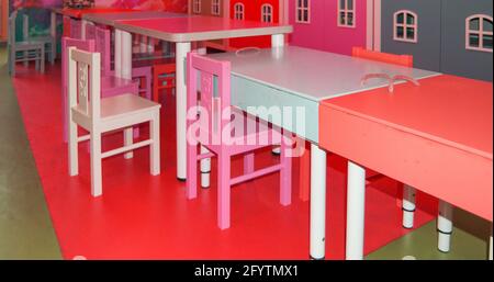 Un ensemble de jolies tables et chaises hautes pour enfants dans la salle de jeux de la maternelle. Banque D'Images