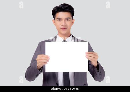 Jeune homme d'affaires asiatique montrant un panneau vide pour la publicité isolé sur fond blanc, homme d'affaires confiant tenant la bannière de panneau d'affichage pour les pres Banque D'Images