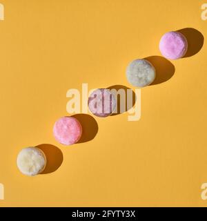 Crème glacée japonaise Mochi dans la pâte de riz. Dessert japonais traditionnel sur fond jaune. Banque D'Images