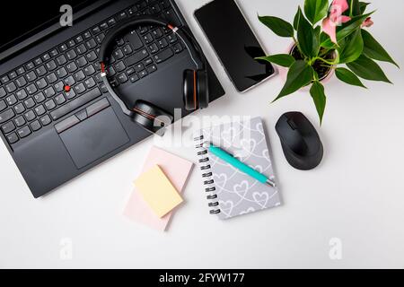 Espace de travail et bureau avec ordinateur portable, casque et smarthpone. Mise à plat sur fond blanc. Banque D'Images