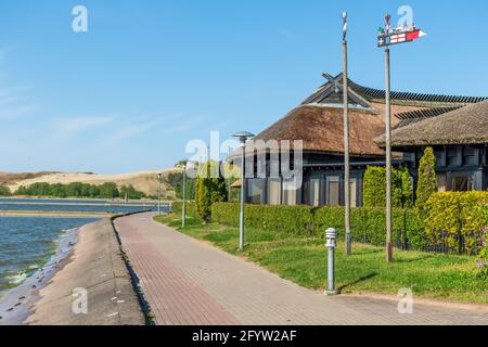 Maisons de pêcheurs. Belles vieilles maisons traditionnelles lituaniennes en bois bleu avec toit de chaume et vieux bateau de la CCuronian Spit dans les pêcheurs de Nida Banque D'Images