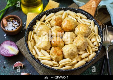 Pâtes italiennes. Spaghetti aux boulettes de viande dans une sauce au fromage sur fond de pierre sombre ou de béton. Banque D'Images