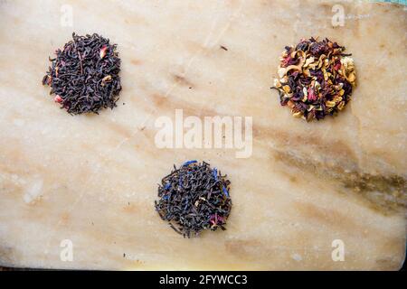assortiment de feuilles de thé de fruits noirs sur un plateau en marbre. Banque D'Images