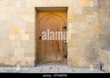 Porte en bois dans le mur d'une maison médiévale. Vieille porte de la vieille ville de Bakou. Banque D'Images