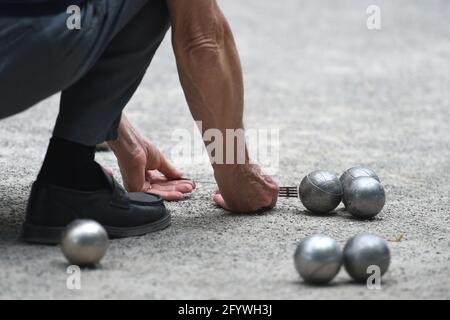 Munich, Allemagne. 30 mai 2021. Sous un ciel bleu-blanc, un joueur de boules mesure la distance entre les boules de boules de la Hofgarten. Le soleil et les températures agréablement chaudes ont attiré de nombreuses personnes à l'extérieur le dimanche. Credit: Felix Hörhager/dpa/Alay Live News Banque D'Images