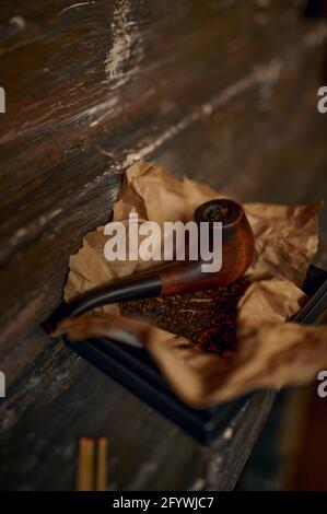Pipe à fumer et pile de tabac sur table en bois Banque D'Images