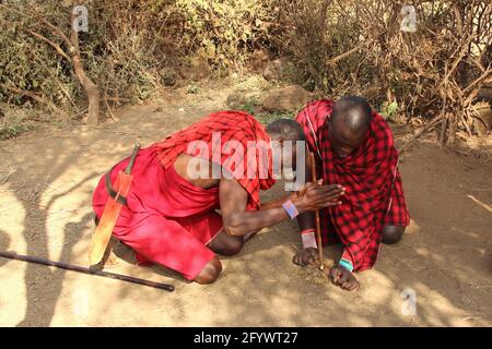 KENYA, PARC NATIONAL D'AMBOSELI - 04 AOÛT 2018 - deux hommes de Maasai montrent la fabrication traditionnelle de feu Banque D'Images