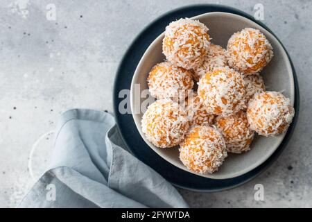 boules de bliss à la noix de coco abricot dans un bol bleu Banque D'Images