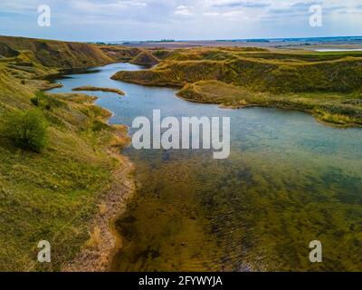 Une vue aérienne d'un étang tranquille trouvé dans une vallée cachée dans les vastes prairies de la Saskatchewan Banque D'Images