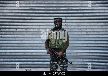 Srinagar, Inde. 30 mai 2021. Un soldat paramilitaire portant un masque facial est alerté sur un marché fermé lors d'un confinement imposé pour empêcher la propagation du coronavirus à Srinagar. Dimanche, le gouvernement a ordonné l'assouplissement des directives de confinement à Jammu-et-Cachemire à partir de lundi, tandis que les établissements d'enseignement resteront fermés jusqu'en juin 15. Pendant ce temps, l'Inde a enregistré une augmentation d'un jour de 165,553 nouveaux cas de COVID-19, le plus bas en 46 jours avec 3,460 décès enregistrés au cours des 24 dernières heures. Crédit : SOPA Images Limited/Alamy Live News Banque D'Images