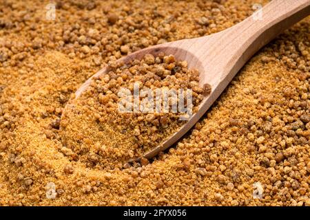 au-dessus de la vue d'une cuillère en bois avec du sucre granulé de fleur de coco gros plan sur la pile de sucre Banque D'Images