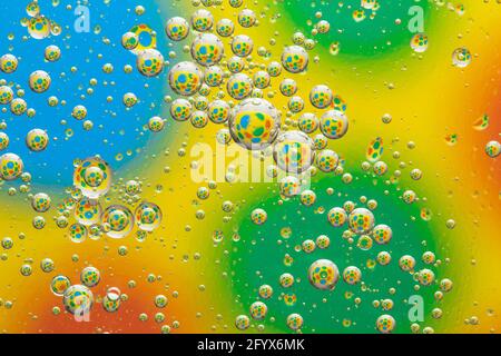 Arrière-plan arc-en-ciel avec bulles, texture gouttes d'eau, motif abstrait cercles multicolores, design artistique créatif, surface liquide colorée. Vert et jaune Banque D'Images