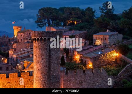 La nuit tombée dans la ville côtière médiévale avec de vieilles maisons en pierre, un mur et une tour, Tossa de Mar, Catalogne, Espagne. Banque D'Images