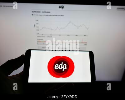 Personne tenant un smartphone avec le logo de la société de services publics Energias de Portugal S.A. (EDP) à l'écran devant le site Web. Mise au point sur l'affichage du téléphone. Banque D'Images