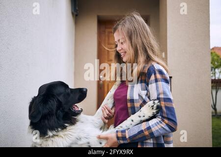 Bonne adolescente renversant chez elle et accueillante avec son chien joyeux (chien de montagne tchèque). Banque D'Images