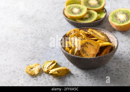 Tranches de kiwi de fruits frais et séchés sur fond de pierre grise, séchage à la maison. En-cas végétalien gratuit. Gros plan. Banque D'Images