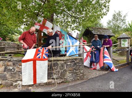 Aston on Clun, Shropshire, Royaume-Uni. 30 mai 2021. Le changement des drapeaux dans le sud du village Shropshire d'Aston sur Clunn dans le cadre du vieux rituel Pagan 'Arbor Day' de la tenue du peuplier noir au centre du village. L'arbre est fraîchement habillé avec des drapeaux, qui restent sur l'arbre tout au long de l'année et le dernier dimanche de mai les villageois se rassemblent autour de l'arbre pour célébrer le jour de l'arbre. Autrefois un festival commun dans toute l'Angleterre, maintenant Aston sur Clunn est le seul village qui maintient toujours la tradition. PHOTO DE DAVE BAGNALL Banque D'Images