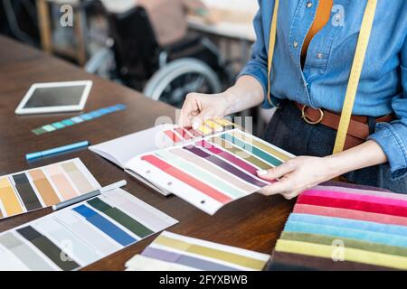 Jeune designer de mode choisissant des couleurs pour une nouvelle collection par table Banque D'Images