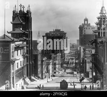 Vue vers l'est sur California Street près de Grant Avenue, San Francisco, Californie, 1915. La tour de la cathédrale Sainte-Marie et le bâtiment Sing Chong sont vus sur la gauche. La tour de l'horloge du Ferry Building est visible au loin. (Photo de Burton Holmes) Banque D'Images