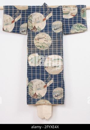 Garçons Miyamairi kimono avec trains, air et expédition. Kimono formel pour un garçon pour la première visite d'un sanctuaire shinto (Miyamairi Kimono), avec un décor de losange blanc sur bleu une décoration de cinq images en forme de rampement: Un train à grande circulation dans un paysage côtier; des navires et des maisons avec grues à four, tout en forme d'origami; Un paysage de montagne avec des zeppelins et des avions; un paysage de montagne avec un téléphérique qui sort de l'avion au-dessus des bâtiments; UNE piste de course avec un poteau à laquelle les lignes avec des drapeaux. Soie bleue avec une décoration en yuzen. Doublure en soie blanche. Banque D'Images