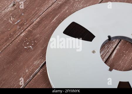 Musique et son - gros plan fragment 265 mm bobine en aluminium bandes magnétiques pour nab sur fond de bois. Banque D'Images