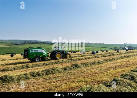 Timoleague, West Cork, Irlande. 30 mai 2021. Lors d'une journée très ensoleillée à West Cork, les entrepreneurs Anthony et Finbarr O'Donovan balles de l'herbe pour l'ensilage sur la ferme laitière de l'agriculteur basé à Timoleague, David Deasy. L'équipement utilisé comprenait un tracteur John Deere 6155R et une presse McHale Fusion 3. Crédit : AG News/Alay Live News Banque D'Images