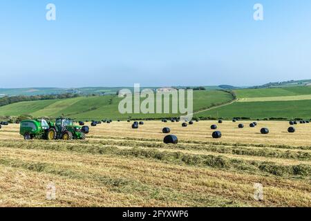 Timoleague, West Cork, Irlande. 30 mai 2021. Lors d'une journée très ensoleillée à West Cork, les entrepreneurs Anthony et Finbarr O'Donovan balles de l'herbe pour l'ensilage sur la ferme laitière de l'agriculteur basé à Timoleague, David Deasy. L'équipement utilisé comprenait un tracteur John Deere 6155R et une presse McHale Fusion 3. Crédit : AG News/Alay Live News Banque D'Images