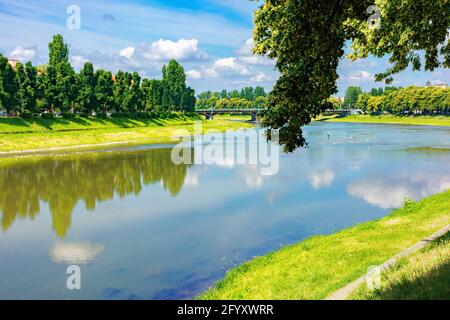 rive de la rivière uzh. magnifique paysage urbain en été. vue de dessous l'ombre d'un arbre de linden branches. pont au loin Banque D'Images